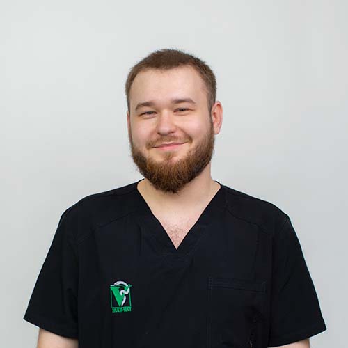 Portret młodego weterynarza, na fartuchy weterynaryjnym widać logo kliniki Multiwet.